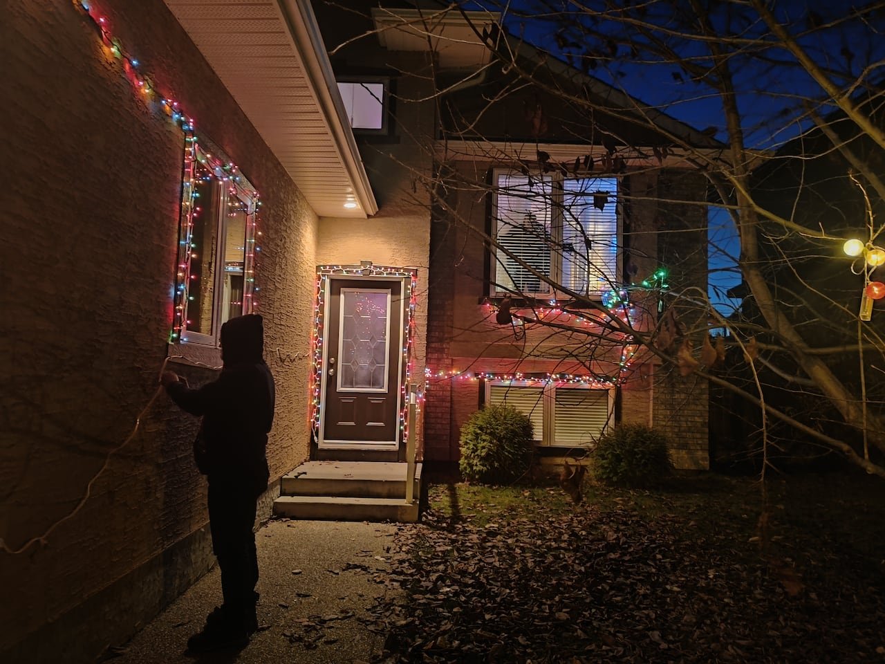 default-424 House adorned with twinkling Christmas lights at night.