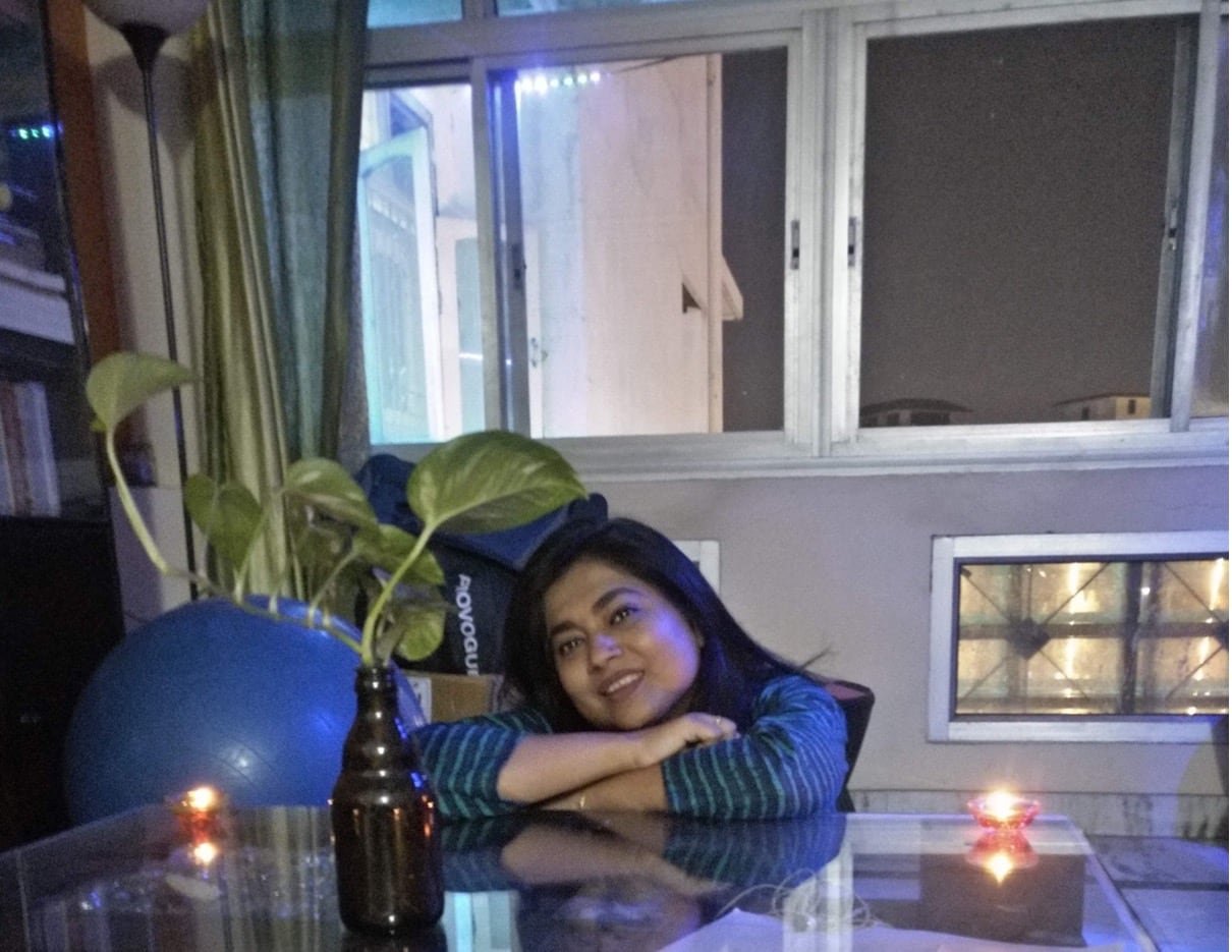default-425 Woman seated at a clear kitchen table with expansive windows in the backdrop.