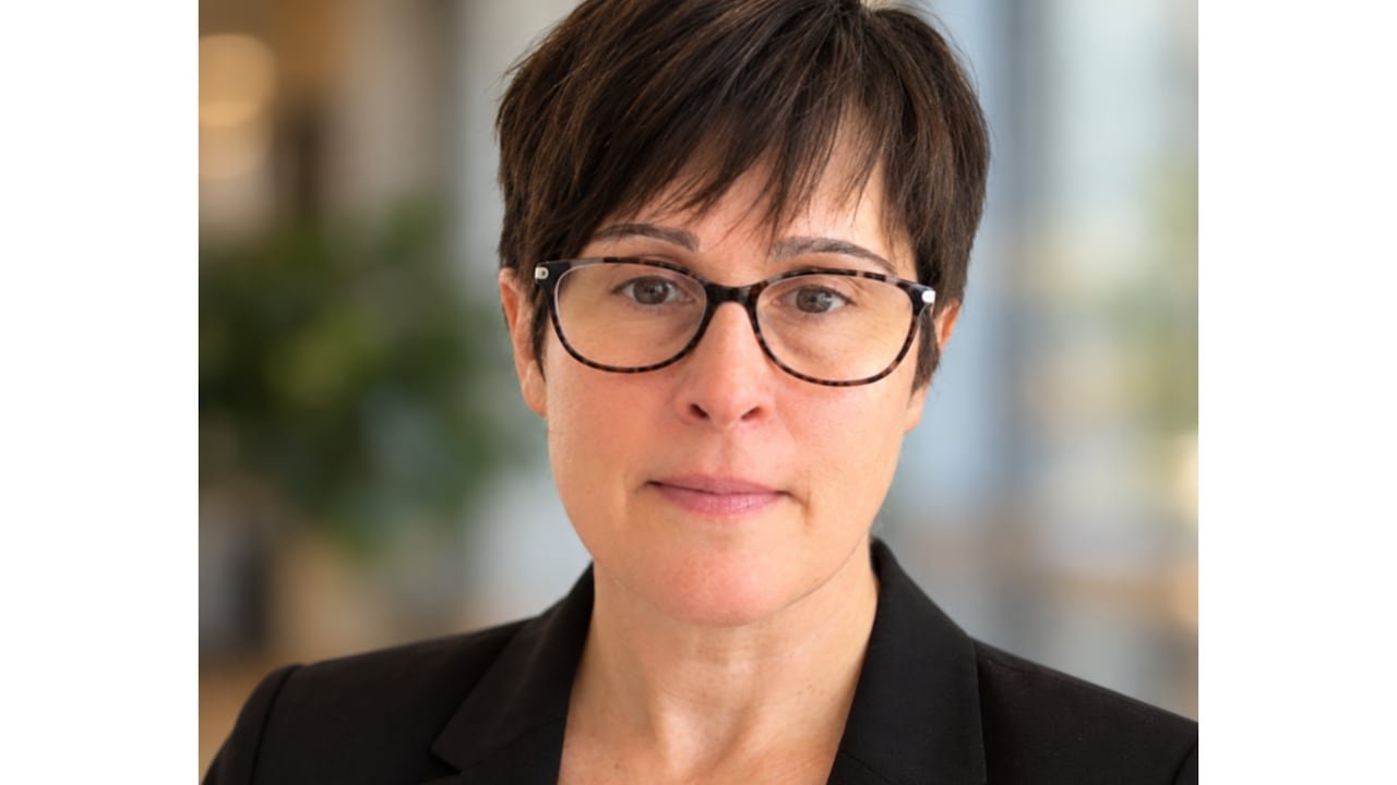 default-639 A woman wearing glasses and short dark hair smiles at the camera.