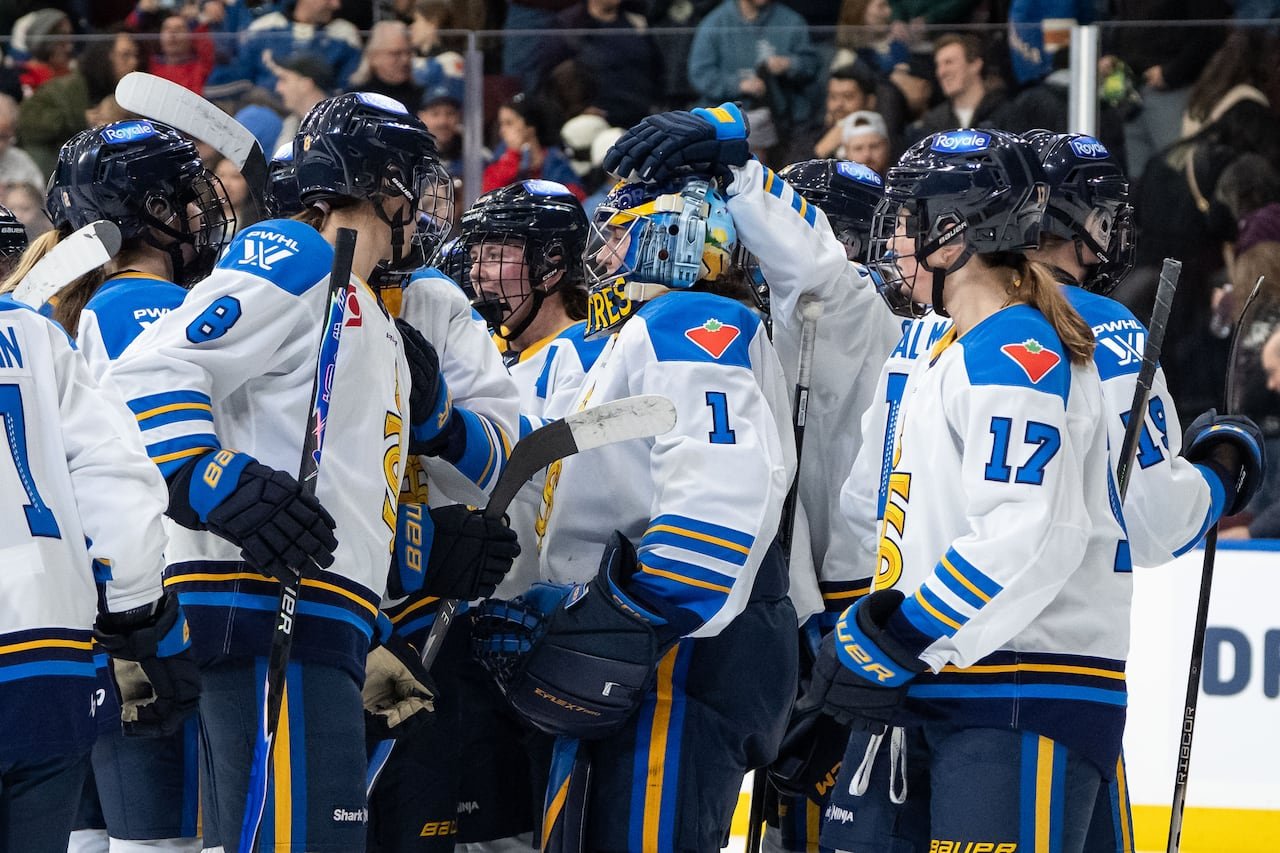 default-720 A group of women in Toronto Sceptres jerseys celebrating on the ice.